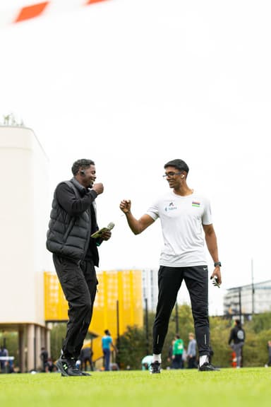 Andre fist-bumping an athlete on the field